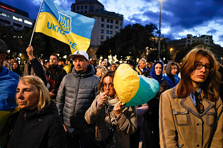 A young protester holds a pair of heart-shaped balloons in the colors of the Ukrainian flag during the rally.