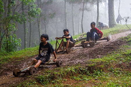 Kids glide at high speed from the top of the track on a bamboo car in Pasir Angling Village. The Traditional games cars made of bambo and wood are again presented by the Pasir Angling village community to introduce and educate children around the village to keep traditional games alive, amid of the technological developments.