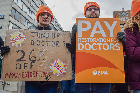 Junior doctors hold placards in support of fair pay at the BMA (British Medical Association) picket outside St Thomas' Hospital as they stage a fresh strike over pay.