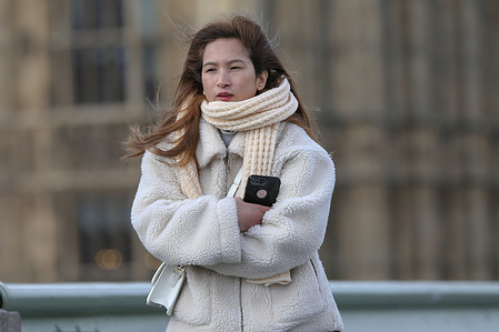 A woman wears a scarf on a cold day in London.