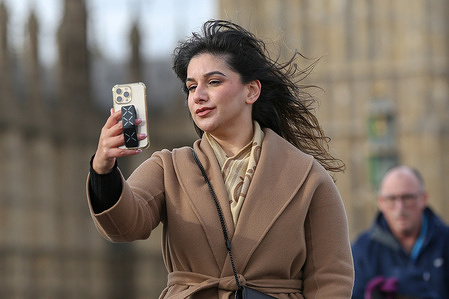 A woman takes selfies in central London. Mobile phones have become an indispensable tool in people's everyday lives.