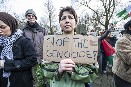 A protester holds a placard expressing her opinion during the "Hands Off Rafah" demonstration in The Hague. Protesters gather in front of the Israeli Embassy in The Hague to call for a ceasefire in Palestine.