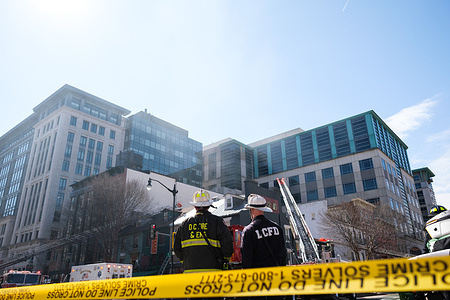 Two DC Firefighters watch on as smoke dissipates after the fire is putout. A fire erupts in Washington, DC's Penn Quarter on the corner of H and 6th Street Northwest in the early afternoon. Firefighters arrive on the scene quickly blocking multiple intersections containing the fire.