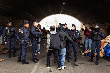 Police officers block the passage of two minor migrants to the camp that was evicted under Pont Marie. A camp of migrant minors beneath Pont Marie on the banks of the River Seine was evicted by police. The rise of waters in the Seine, which caused several floods, motivated this operation, but for activist associations this was used as a pretext for cleaning up the areas where migrants live ahead of the Olympic Games. There are around 400 migrants, many of them unaccompanied minors, who had to abandon the banks of the Seine, without receiving any shelter solution from Paris City Hall.