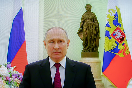 A picture taken of a screen shows Russian President Vladimir Putin congratulating Russian women on International Women's Day on March 8 via video conference in the Kremlin.