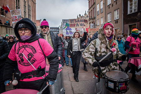 Protesters march through the streets while playing drums during the women's demonstration. A demonstration in defense of women's rights and all discriminated social groups passed through the streets of Gdansk. This was the 20th time that women demanded equal rights and the fulfillment of election promises, including access to safe, legal abortion, a change in the definition of rape, equal pay, or effective action against violence. The manifestation's slogan is "Enough promises, time for action". A minute's silence was also held to commemorate the brutal rape and death of a 25-year-old Belarusian girl, Liza, in Warsaw on 25 February. The young girl died in hospital a few days after the assault.