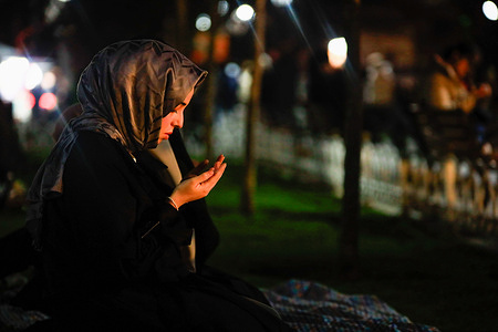 A girl prays after breaking fast at the glory square of Hagia Sophia in Istanbul on the first day of Ramadan. Ramadan cannon was fired in Hagia Sophia Grand Mosque which was witnessed by hundreds of Muslims in Istanbul. This tradition, deeply rooted in Turkish culture, signifies the conclusion of fasting and the commencement of Iftar. The cannon is usually fired at sunset from the highest point in the city so that everyone can see and hear.