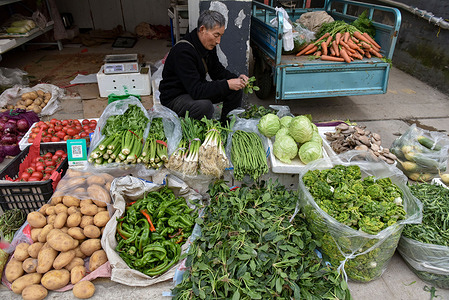 A male vendor seen selling vegetables, placed in front of potatoes, green Onions, green peppers and other vegetables. According to the Chinese government Work Report, the consumer price index, (CPI) will be increased around 3 percent in 2024.