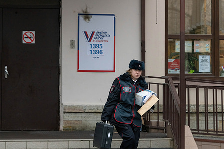 Police investigate the area after a woman threw a Molotov cocktail at a poster at the entrance of a school, which serves as a polling station during the presidential elections in St. Petersburg. March 15 to 17, presidential elections are taking place in Russia.