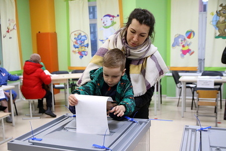 A woman with a child cast their vote at a polling station during the presidential elections in Russia in 2024. Four candidates are participating in the elections: the leader of the LDPR Slutsky, a member of the Communist Party Kharitonov, the current head of state, self-nominated Putin and a member of the New People party Davankov.