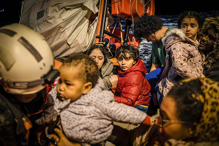 Young children rescued by MSF team ready to embark on Geo Barents. During the night of March 16, 2024, the MSF crew intercepted a small fiberglass boat full of migrants navigating towards Europe in the Libyan SAR zone. The boat had more than 60 people on board, including many women and children. At the time of the rescue the vessel was already in very precarious conditions and during the operations it capsized.