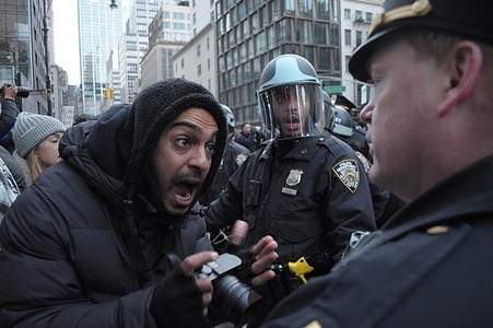 A member of the New York City Police Department, right, clashes with a person holding a camera, left, during a pro-Palestine march. Demonstrators rallied in Manhattan, New York City condemning the Israel Defense Forces' military operations at al-Shifa Hospital in Gaza City. The IDF said its troops began raiding the hospital to target Hamas members on Monday, March 18. Gaza's health ministry, which is run by Hamas, said Israel's raid is a war crime as thousands of civilians are sheltering in the hospital. Since the war started on October 7, 2023, Gaza's health ministry said more than 31,000 people have been killed in Gaza, a territory ruled by Hamas. The death toll does not differentiate between civilians and combatants.
