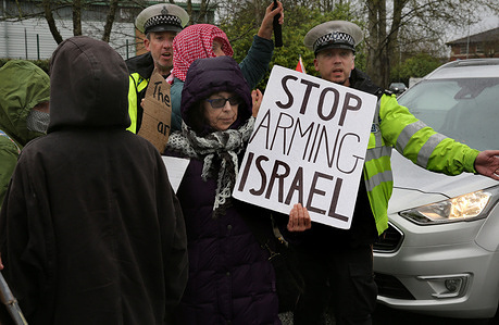 Police officers encourage a protester holding a sign reading ‘Stop Arming Israel’ out of the road so workers can gain access to their workplace. Protesters gather outside the gates of Elbit System’s factory in Leicester to confront workers as they arrive for work with signs and chants that let them know what they think of the Israeli arms company and their role in oppressing Palestinians in Gaza and elsewhere. March 20th saw national action outside arms factories complicit as the protesters see it in the Israeli genocide in Gaza.
