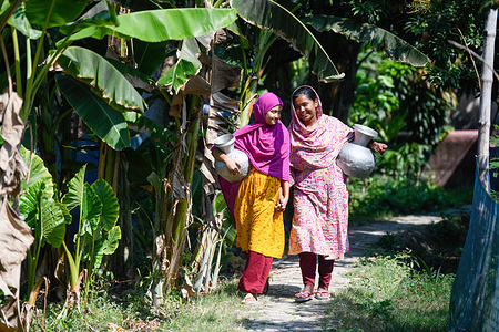 Young women seen returning from fetching drinking water from a reverse-osmosis plant set up by a local Non-Governmental Organization (NGO) at Shyamnagar Gabura in Satkhira district. In Gabura Union, located in Shatkhira District, southern Bangladesh, residents are facing a serious drinking water shortage worsened by climate change. People, including women and children, have to travel long distances every day to find safe water sources. Recent data from the coastal district shows high percentages of people struggling with water scarcity, with environmentalists warning that the situation is even worse than reported. The underground water levels are decreasing, making deep tube wells insufficient, and the rising salinity due to climate change is further limiting access to safe drinking water in the area.