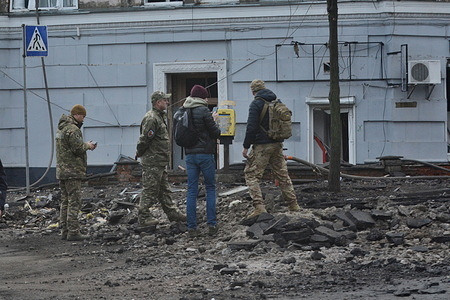 Forensic experts examine the site of a rocket crater on the road after a rocket attack in Kyiv. Ukrainian air defence forces shot down "about three dozen enemy missiles, including ballistic missiles, over Kyiv and in the vicinity of the capital," the city's military administration said on Telegram, adding that the raid had lasted three hours.