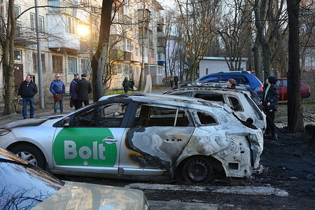 Local residents inspect burnt cars near the site where a rocket debris fell after its attack. Ukrainian air defence forces shot down "about three dozen enemy missiles, including ballistic missiles, over Kyiv and in the vicinity of the capital, " the city's military administration said on Telegram, that the raid lasted about three hours.
