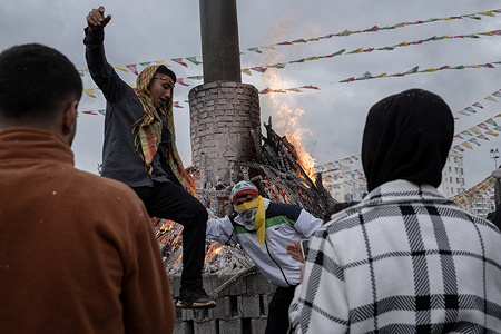 Two young people are having fun around the Newroz Fire. Thousands of people gathered in Diyarbakir and celebrated Newroz, which is considered the arrival of spring and the new year of the Persian calendar. They filled Newroz Park with green, red and yellow flags and had fun singing Kurdish songs.