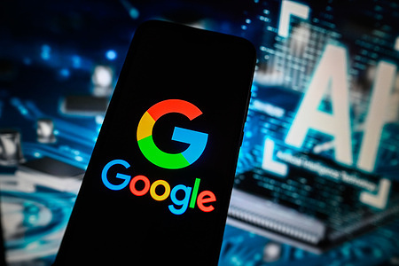 In this photo illustration a Google logo is displayed on a smartphone with Artificial Intelligence symbol on the background.