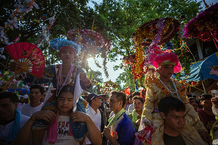Young ethnic Shan boys dressed in colorful costumes are being carried on the shoulders of their family members during an annual Poy Sang Long procession, a traditional rite of passage for boys to be initiated as Buddhist novices at Wat Ku Tao Temple. Poy Sang Long is a Buddhist novice ordination ceremony, of the Thai Yai tribal people, but unlike any other ceremony of its type in the country. Young boys aged between 7 and 14 are ordained as novices to learn Buddhist doctrines.