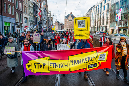 People march while holding a banner against ethnic profiling. People gathered at the Dam Square in Amsterdam to ask for diversity, solidarity, and against all forms of racism and discrimination to mark the Elimination of Racial Discrimination Day.
