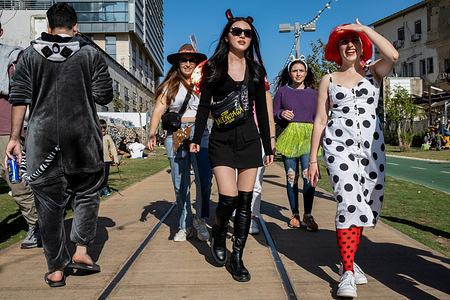 Young women walk along the HaMesila Park. Purim is a Jewish holiday commemorating the salvation of the Jews in ancient Persia from a plot to annihilate them. A joyous holiday, It is celebrated by both secular and nonsecular Jews, most notably by dressing up in costumes and partying.