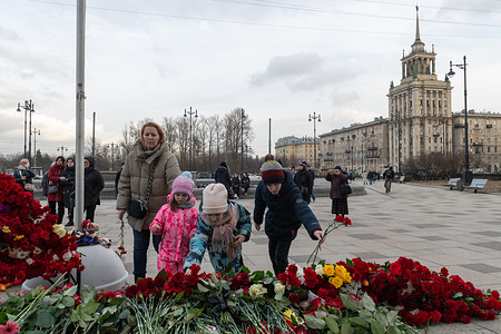 People lay flowers at the makeshift memorials for the victims of the terrorist attack at the "Crocus City Hall" concert venue in the Moscow region. In Russia, March 24 is a national day of mourning for the victims of the terrorist attack.