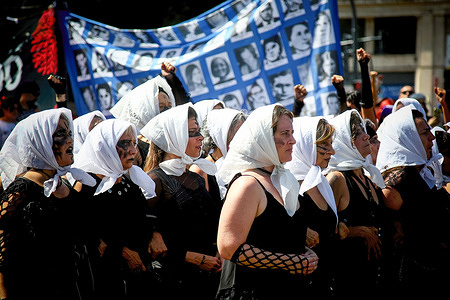 Protesters walk wearing white scarves on their heads during a demonstration to commemorate the 48th anniversary of the 1976 military coup. Argentines mark the National Day of Remembrance for Truth and Justice by honoring victims of the military dictatorship.