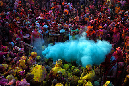 Hindu devotees play with colorful powders (Gulal) at the Radharani Temple of Nandgaon during the Holi festival. Holi Festival of India is one of the biggest colorful celebrations in India as many tourists and devotees gather to observe this colorful event, which marks the beginning of spring. The festival celebrates the divine love of Radha and Krishna and represents the victory of good over evil.