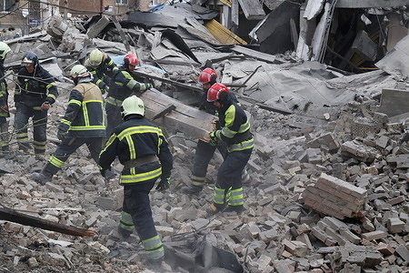 Ukrainian rescuers work at the site of a missile attack in Kyiv amid the Russian invasion of Ukraine. Five people including a teenage girl were injured on March 25, 2024 during a Russian missile attack on Kyiv, where falling debris also damaged at least two buildings in central districts. Russia has escalated aerial attacks on Kyiv in recent days, targeting key infrastructure in the wake of fatal Ukrainian bombardments on Russian border regions.