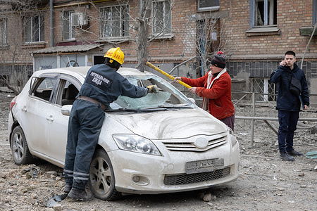 A rescuer and a resident clear a car damaged by a Russian missile attack in central Kyiv. A three-story building of the Kyiv Academy of Art and Design was destroyed as a result of the morning rocket attack in Kyiv. According to the State Emergency Service, at least ten people were injured.