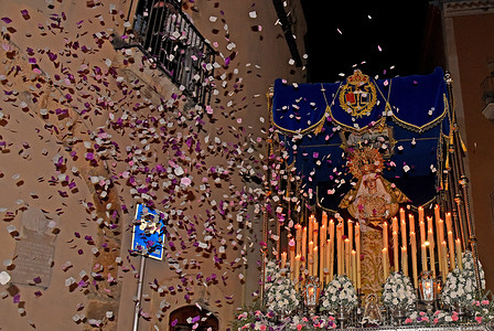 People from a balcony throw flower petals at the passing of the Virgen del Consuelo during the Palm Sunday parade in Vendrell The Brotherhood of "Las Penas de El Vendrell" accompanied by the Virgen del Consuelo Musical Group carries out the Palm Sunday procession, parading through the streets with the "Virgen del Consuelo" and "Jesús de las Penas" to celebrate Easter Week