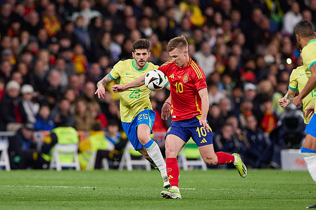 Dani Olmo (R) of Spain with Lucas Beraldo (L) of Brazil in action during the international friendly match between Spain and Brazil at Santiago Bernabeu Stadium. Final score: Spain 3:3 Brazil