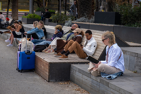 A group of people rest and sunbathe while reading or listening to music at the port of Barcelona. Barcelona has a hotel occupancy rate of over 80% planned for the Easter holidays. For residents, the increase in visitors and tourists in the streets and squares visiting the city's architectural heritage during Holy Week is already noticeable.