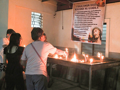Christians light candles in observance of the Holy Week's Maundy Thursday. Catholic Christians continue to flock to Bangkulasi Chapel, evening of Maundy Thursday in Navotas City to get a glimpse of the Sto. Entierro or the replica of the sleeping Christ. Navoteños call it as the "Mahal na Señor ng Bangkulasi". some Christians wipe the glass containing of the replica or touch it to pay their respect.