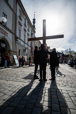 People wearing white masks hold wooden crucifix as they take part during the Good Friday procession on the streets of Trebon. Sound of Easter rattling is supposed to replace the ringing of the bells from churches.