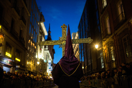 A Nazarene from the National Primary Archconfraternity of the Royal and Illustrious Slavery of Our Father Jesus the Nazarene carries a giant cross during the procession with the image of Jesus of Medinaceli through the streets of Madrid on Good Friday. The statue of Jesús de Medinaceli, also known as the Lord of Madrid, is very important to the city. It was carried around the city during the Good Friday procession.