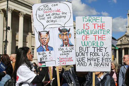 Pro-Palestine protesters hold placards during the 11th rally in Trafalgar Square in central London, demanding immediate ceasefire, following Israel's bombardment on the Gaza strip.