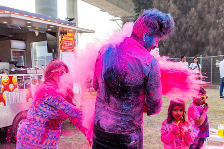 A man is hit by a huge handful of pink powder thrown by a family member during an event to celebrate the Holi festival. At the park in Docklands, Melbourne's contemporary inner-city suburb, the Holi festival is a vibrant expression of cultural harmony. As the sounds of Indian music fill the air, Melbourne's diverse community comes together, embracing the spirit of Holi and celebrating the city's multicultural tapestry.