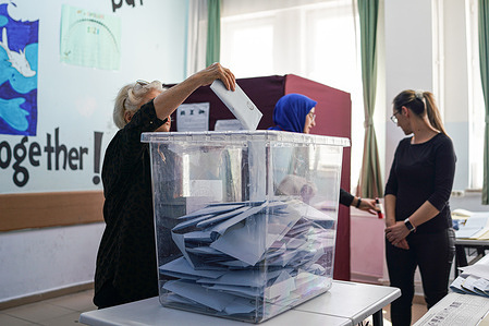 A voter casts her vote in a ballot box at a polling station during the 2024 Turkish local elections. In the 31 March 2024 General Elections for Local Authorities, more than 61 million voters are voting in approximately 208 thousand ballot boxes. 35 political parties participated in the elections.