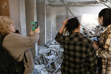 A teacher takes a photo in the hallway of Kyiv State Academy of Decorative Applied Arts and Design after it was damaged in a missile strike in Kyiv. An educational building housing the State Academy of Decorative Applied Arts and Design was damaged as a result of a Russian rocket attack on March 25, 2024.