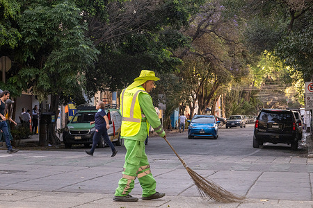 City worker sweeps the street in Mexico City. The city street sweepers in Mexico City conscientiously undertake the task of cleansing the thoroughfares, thereby upholding standards of tidiness and aesthetic appeal essential for the urban environment. Their dedicated efforts play a pivotal role in sustaining the cleanliness and hygiene of the cityscape, benefiting both its inhabitants and tourists.
