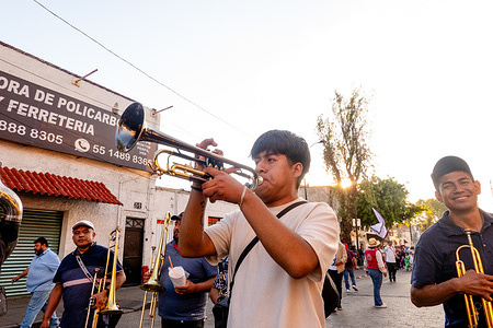 A musician plays a trumpet as he participates in the 2024 Xochimilco Carnival in Xochimilco, Mexico City, Mexico. The Xochimilco Carnival in Xochimilco, Mexico City, Mexico, is a lively celebration filled with colorful parades, traditional music, and elaborate costumes. It has deep historical roots tracing back to pre-Hispanic times when indigenous communities held ceremonial festivals to honor their deities and mark agricultural cycles.