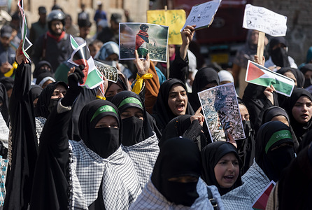 Kashmiri Muslim women shout Anti Israel and Anti America slogans as they hold posters depicting support for Palestine during a rally marking Quds day in Srinagar outskirts. (Al-Qud) is the Arabic name For Jerusalem. An initiative started by the late Iranian revolutionary leader Ayatollah Ruhollah Khomeini, Al Quds Day is celebrated globally on the last Friday of the Holy month of Ramadan to show support for Palestinians and condemn Israel.