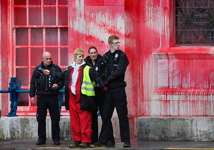 A protester is searched and arrested after being removed from their lock-on during a demonstration outside Somerset County Hall. Supporters of Palestine Action staged a protest at County Hall, blocking the entrance and splattering red paint on the building. They demand Somerset Council terminate its lease with Elbit Systems in Bristol, citing Elbit's weapons' use by the Israeli Defense Force against Palestinians. With over 30,000 Palestinians killed by Israeli bombings since October 2023, Palestine Action aims to disrupt Elbit's UK operations, as seen with the recent closure of their Tamworth factory.