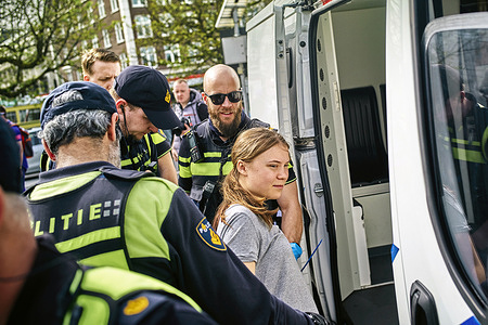 Greta Thunberg got arrested together with other protesters as she was blocking the road (S100) in the centre of The Hague. A small group of protesters blocked the road (S100) in the centre of The Hague during an Extinction Rebellion movement. Initially the activists wanted to block the A12 for the 37th time but they didn’t succeed in taking the road as Police officer surrounded and arrested them. Protesters were carrying “XR” flags and placards saying "Stop fuel subsidies now!" and "The planet is dying!".