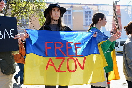 A woman is holding a Ukrainian flag with an inscription 'FREE AZOV' during an action 'Don't Be Silent. Captivity Kills' in Kyiv. Relatives and friends of the soldiers came to draw attention to the military who are still in Russian captivity. The organizer of the rally are the community of families of soldiers missing.