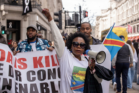A protester holds her fist up during the marching in London. Congolese diaspora and their allies protested front of the London HQ of Apple against the violence and the mineral exploitation in Eastern part of the Democratic Republic of Congo (DRC), where the fights is going on between the Congolese forces and the Rwanda backed M23 rebel group. The conflict created a growing refugee crisis, human right abuses and cheap labor for mining. All minerals like Coltan, Cobalt, etc. which are used by companies like Apple on phones and batteries.