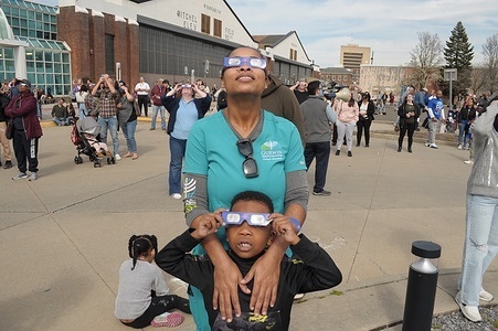 Attendees wear glasses to see a partial solar eclipse outside of the Cradle of Aviation Museum's Solar Eclipse Viewing Party and Activities event in Garden City, Nassau County, Long Island, New York. A solar eclipse moved across North America, completely blocking the sun in its path over certain areas of Mexico, the United States and Canada. Most American locations, including Long Island and New York City, witnessed a partial eclipse. The eclipse was caused by the moon orbiting in between the sun and the Earth, temporarily blocking the sun. The next total solar eclipse over the U.S. will occur in 2044.