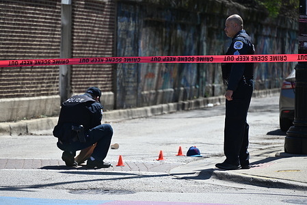 Police officers from the Chicago Police Department mark where shell casings were found and other evidence items, at a crime scene that left one injured and another dead. Two people shot, one killed in broad daylight in Chicago, Illinois, United States. A 41-year-old male and a 33-year-old male were outside at the 6900 block of N. Glenwood Avenue Tuesday morning at approximately 11:16 a.m. when an unknown offender approached and began to fire shots in their direction. The 41-year-old male victim sustained a gunshot wound to his back and was transported to the hospital, in good condition and the 33-year-old male victim sustained a gunshot wound to his back and was transported to the hospital, where he was pronounced dead. No one is in custody and Area Detectives are investigating.