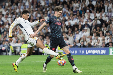 (L-R) Jude Bellingham of Real Madrid and John Stones of Manchester City in action during the UEFA Champions League 2023/24 round of 8 first leg match between Real Madrid and Manchester City at Santiago Bernabeu Stadium. Final score; Real Madrid 3:3 Manchester City